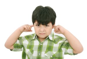 Young boy with his fingers stucked in his ears