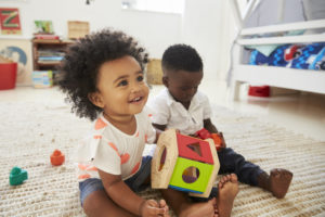 Small boy and girl play with toys in the playroom