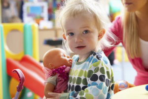 A little girl holding a baby doll