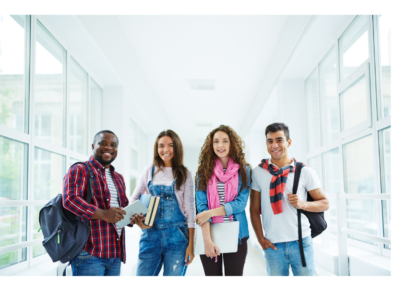 High school students standing in a hallway with a lot of windows.