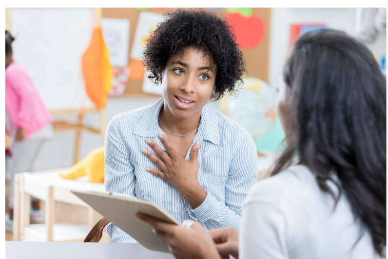 Parent and teacher talking at a meeting.