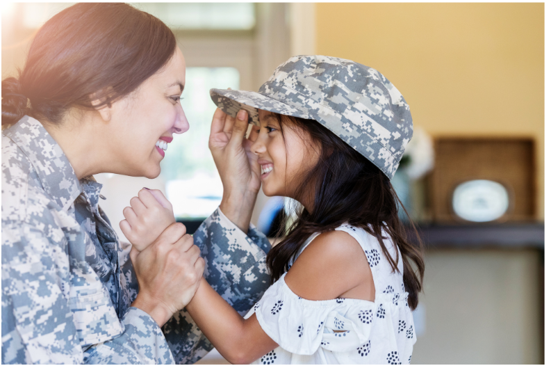 Mom in the military with daughter wearing military hat.